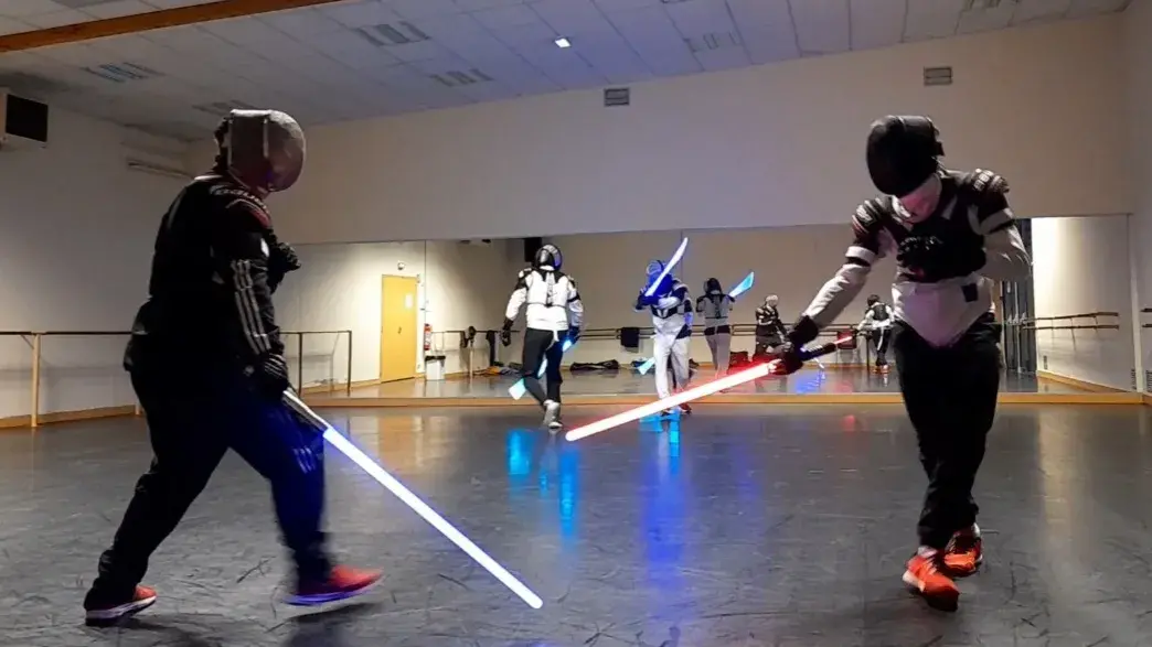 Groupe en garde, sabres laser rouges et bleus allumés.